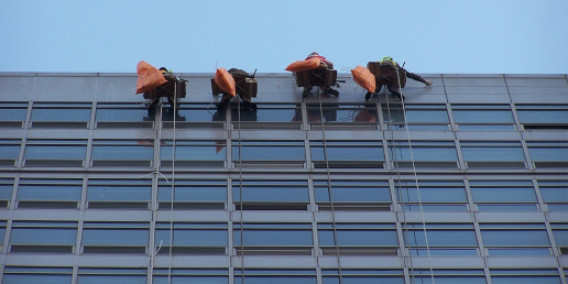Cleaners providing commercial window cleaning services on an office.